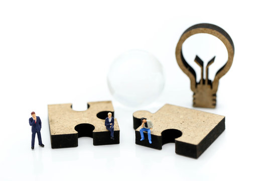 Miniature people : Businessman with jigsaw and idea lamp using for concept of swap idea day.
