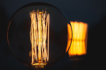 Retro stylized large tungsten lamp in dark