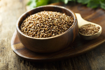 Raw buckwheat in the wooden bowl
