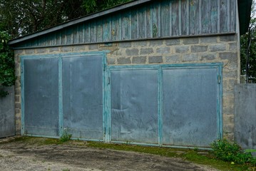 Private garage with two metal gray gates on the street