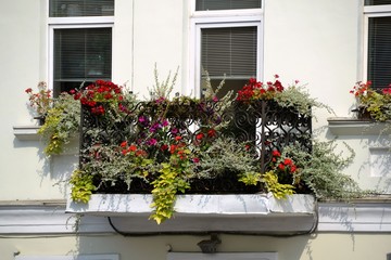 Fototapeta na wymiar Уютный балкон жилого дома, украшенный цветами