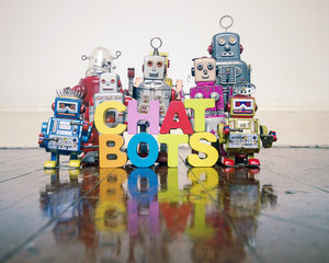 CHAT BOTS wooden letters and retro robot toys on a wooden floor