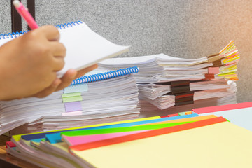 Teacher hand holding pen for checking student's homework assignment with separated by colorful...