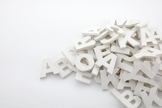 Pile of white painted wooden letters. Typography background composition.