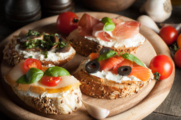Italian tomato and cheese bruschetta. Tapas, antipasti with chopped vegetables, herbs and oil on grilled ciabatta and baguette bread.
