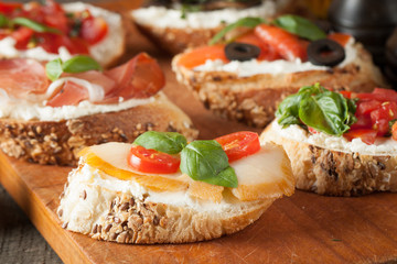 Italian tomato and cheese bruschetta. Tapas, antipasti with chopped vegetables, herbs and oil on grilled ciabatta and baguette bread.