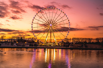 Illuminated ferris wheel with colorful sunset. - obrazy, fototapety, plakaty
