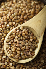 Raw buckwheat in the wooden bowl