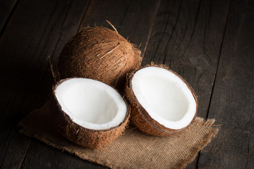 Ripe half cut coconut on a wooden background. Ripe half cut coconut on a wooden background. Coconut cream and oil.