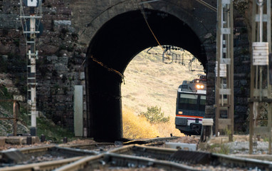 Fototapeta na wymiar electric train enters tunnel to station