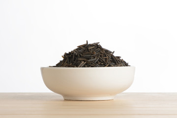 Arroz salvaje en un bol de cerámica blanca sobre la mesa de madera