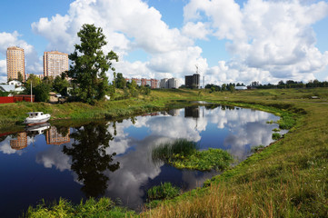 Fototapeta na wymiar Mirror-smooth river in bright sunny weather.
