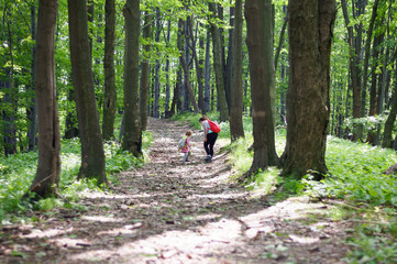 Obraz premium A girl with her mother on a trip in the mountains, a scene in the forest.