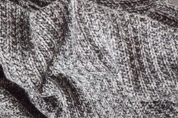 Fototapeta na wymiar Warm wool gray knitted crumpled plaid. Home cosiness