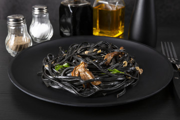 Pasta with wheat germ and black squid ink. Mushroom sauce. Olive oil and spices. Copy space.