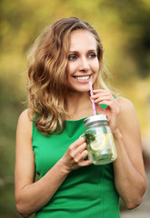 Kobieta w zielonej sukience pijąca wodę z mięta i cytryną © mycatherina