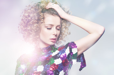Fototapeta premium A young woman in a shiny dress dancing in the bright rays