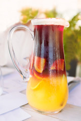 tall glass jug pitcher of ice cold yellow and red sangri