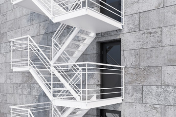 Gray bricks building, fire escape stairs side view