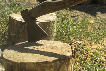 An axe in the wooden stump.