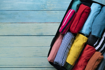 close up of rolled colorful clothes in a luggage for a new journey