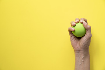 woman holding stress ball on yellow background