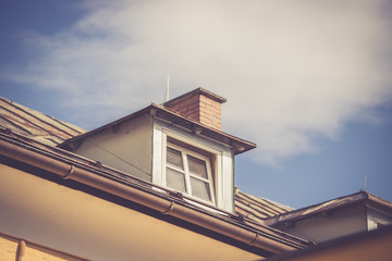 Dachfenster eines Hauses, blauer Himmel