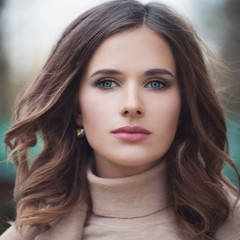 Naklejka premium Young romantic woman with curly hair outdoor. Beautiful female face closeup