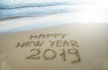 Happy new year written on the sand