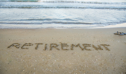 Retirement written on sand by sea at beach