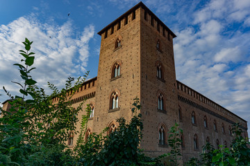Fototapeta na wymiar The facade of the Visconti Castle ( castello visconteo ). Medieval building with red brick facades in Pavia, Lombardy, Italy