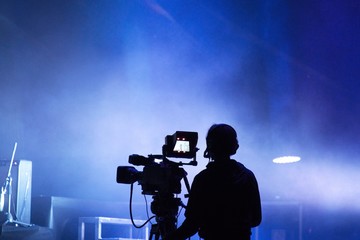 Sagoma di un cameraman durante un concerto. Sfondo blues