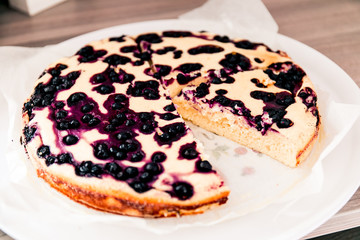 Cut homemade casserole pie with cottage cheese with blueberries.