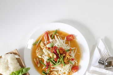 Som tam thai, green papaya salad on white table with space.