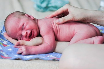 A newborn baby in the mother's arms.