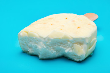 white popsicle with some bites on blue background