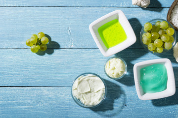 beauty product samples from grape seed ingredient, blue wooden table background