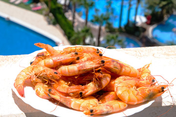 Fried shrimps on the plate near the pool