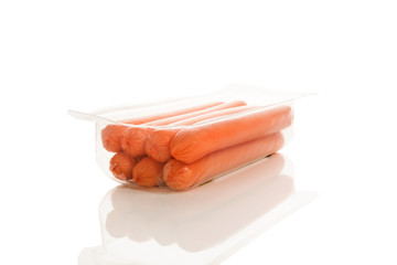 Sausages in transparent box on white.