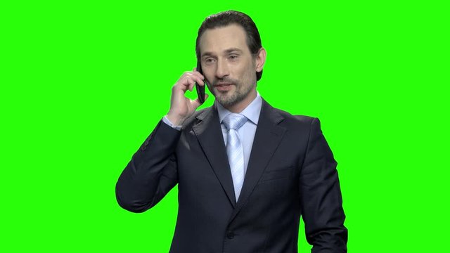 Businessman making profitable agreement using phone. Happy mature man in suit rejoicing success. Green screen hromakey background for keying.