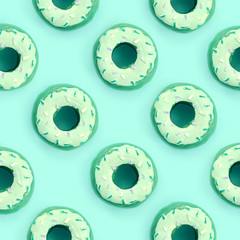 Many small plastic donuts lies on a pastel colorful background. Flat lay minimal pattern. Top view