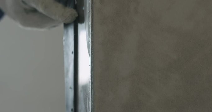 Slow motion worker applying putty on the wall with copy space