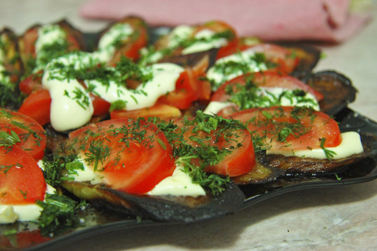 Fried eggplants and fresh tomato with souce and herbs