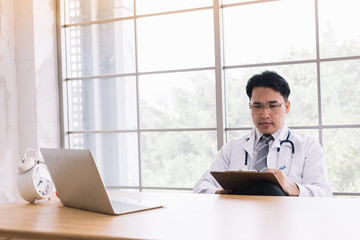  doctor working with the computer and writes the patient's documents in the hospital.