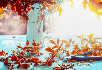 Autumn  flowers bunch and vase on blue table with sunshine. Cozy home interior decoration. Fall...