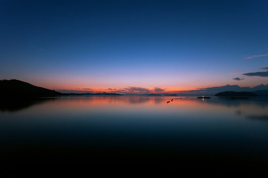 Long exposure image of Dramatic color sky seascape with reflection in sunset or sunrise scenery nature for background.