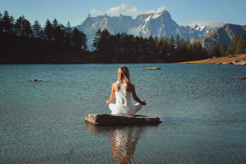 Woman meditation in mountain lake - 221580230