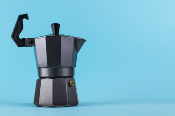 A metal, geyser coffee maker on a blue background. Coffee concept. Cheerfulness, early awakening, energy. Copy space