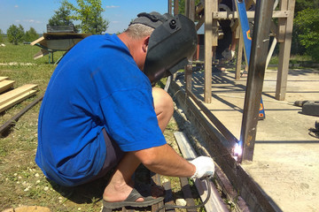 a man weld metal on the street