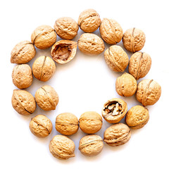whole walnuts circle with two cracked nuts isolated on white